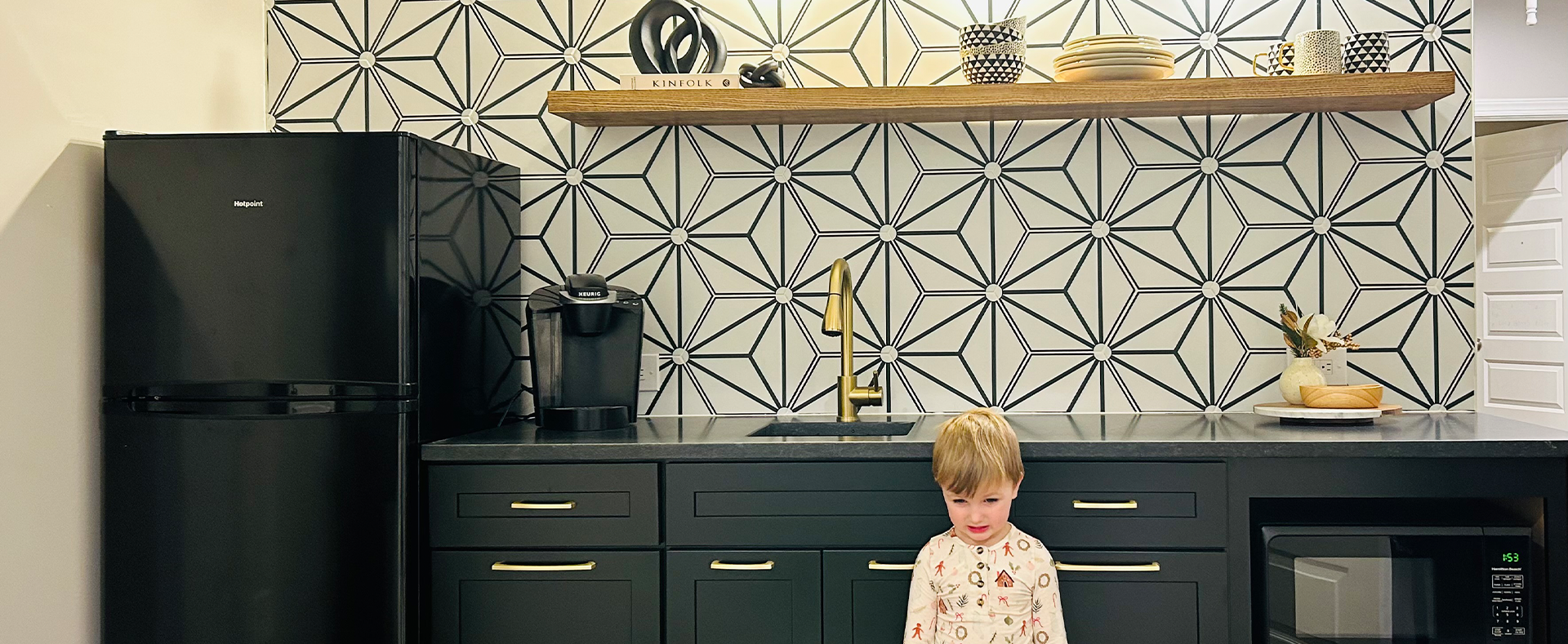 A young child standing in front of the sink.