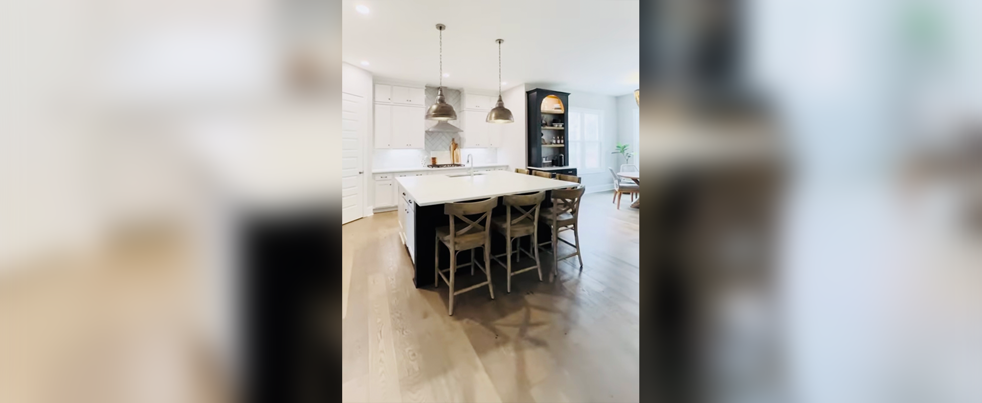 A kitchen with a large island and wooden floors.