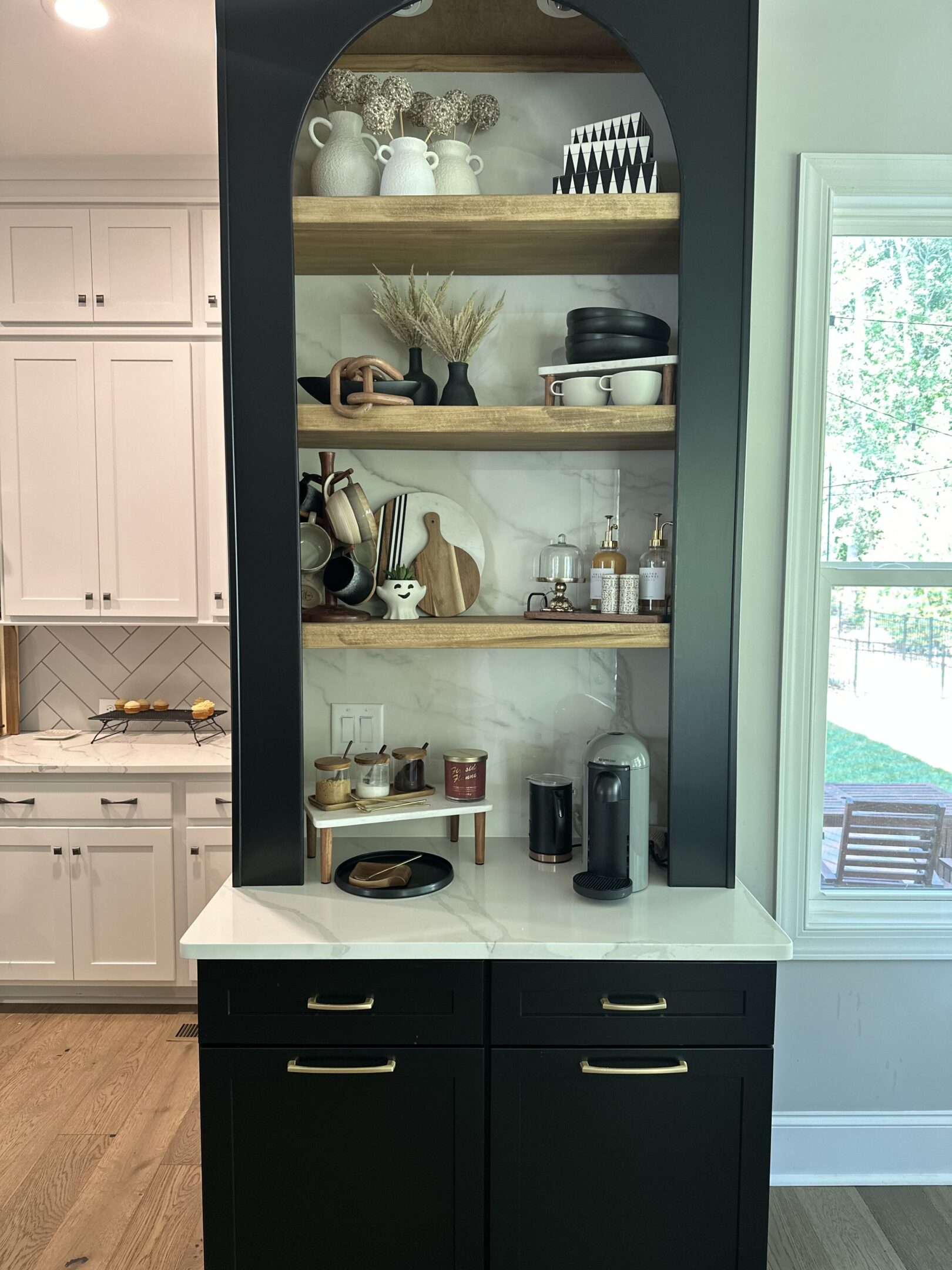 A kitchen with black cabinets and white counters.