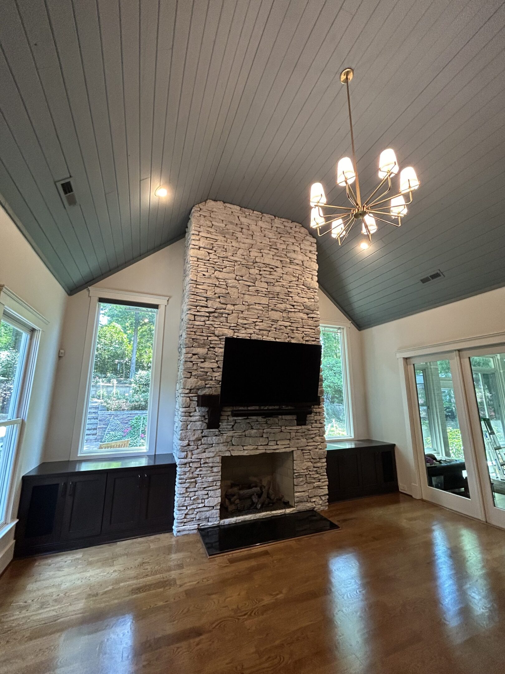 A room with a fireplace and two windows.