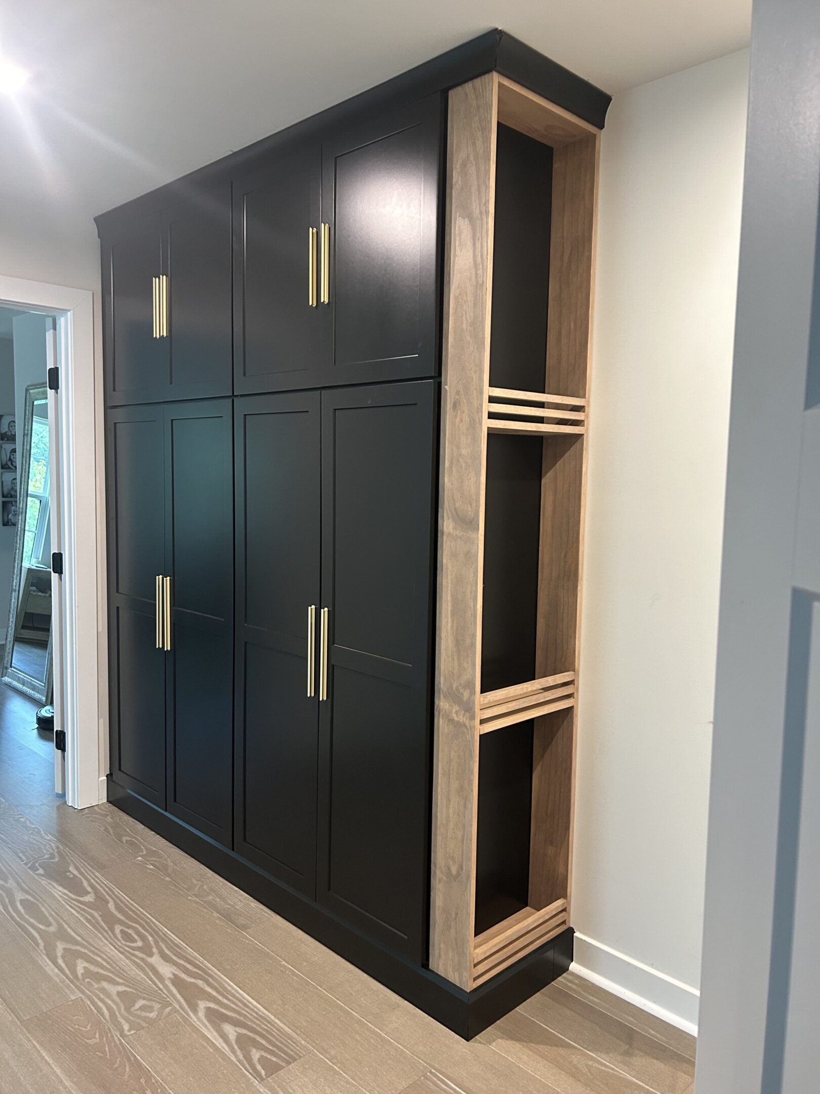 A black cabinet with gold handles and some wood