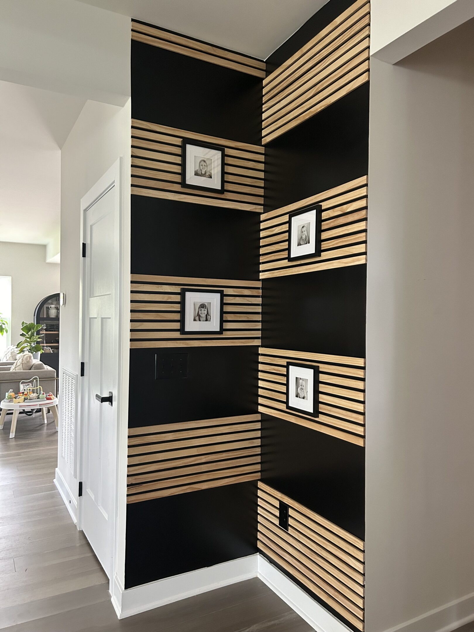 A black and white striped wall with pictures on the walls.