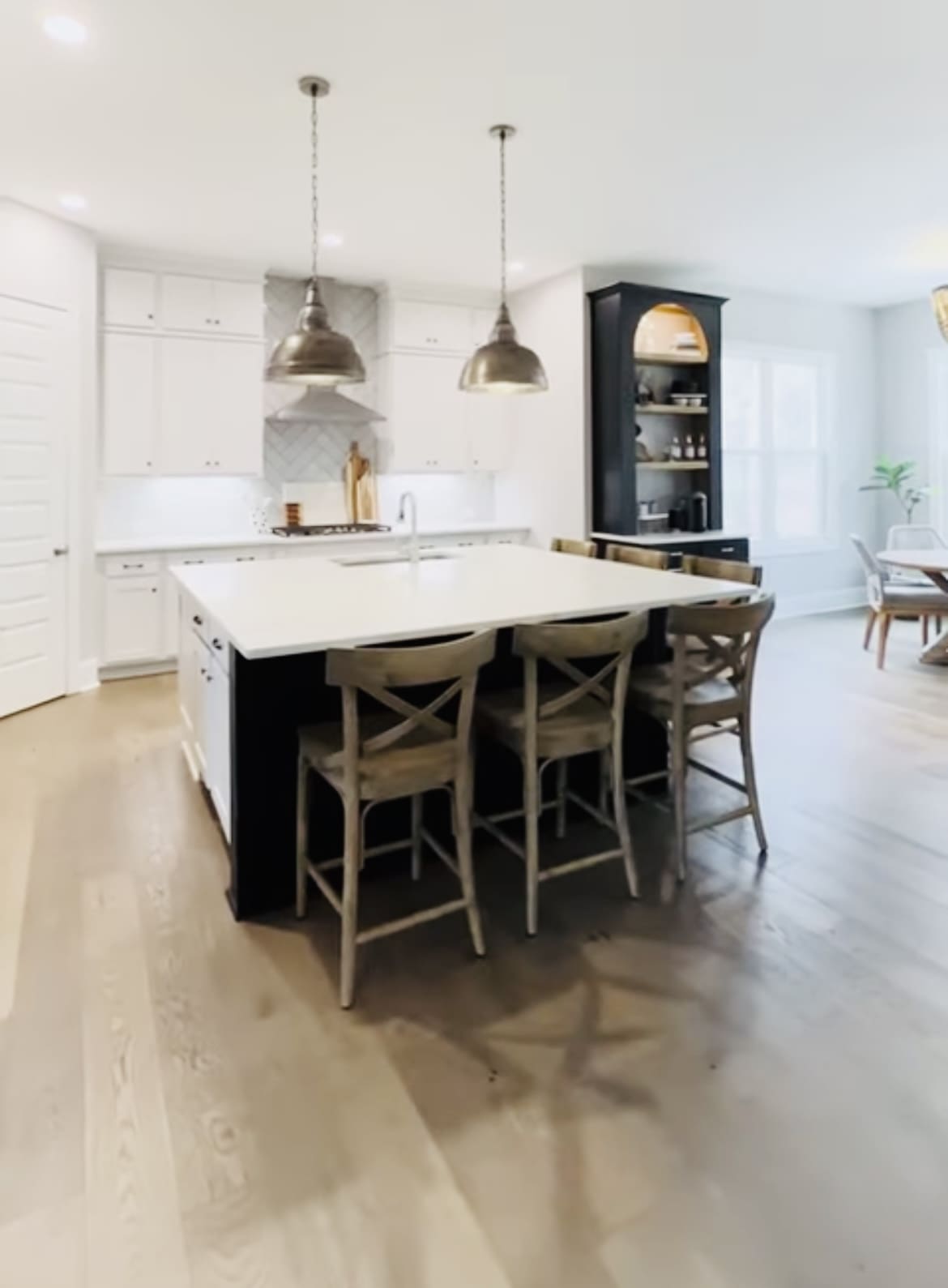 A kitchen with a large island and wooden chairs.