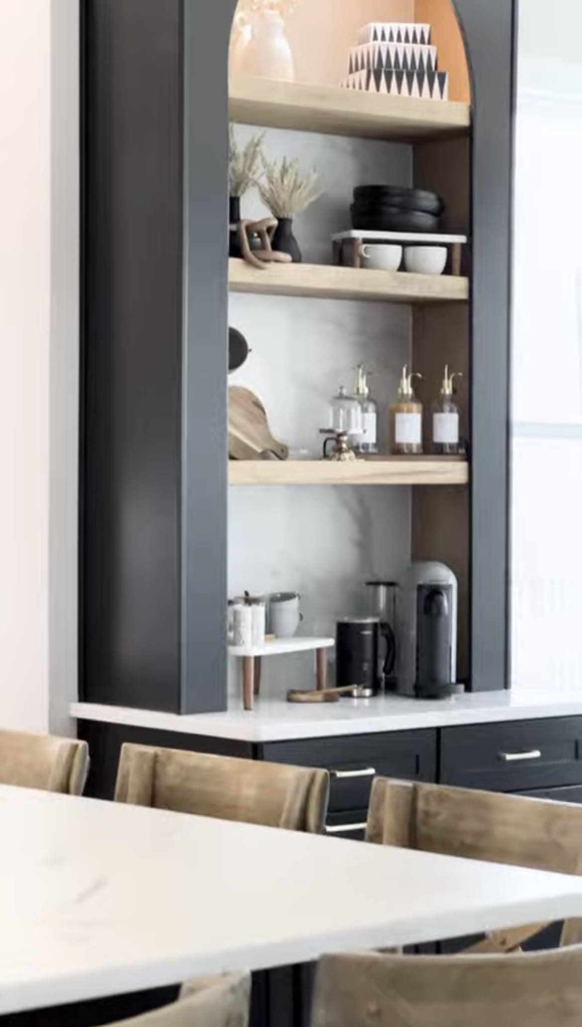 A kitchen with black cabinets and white counter tops.