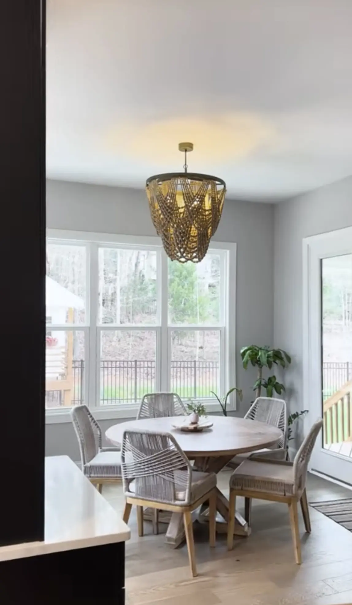 A dining room with a table and chairs, and a chandelier.