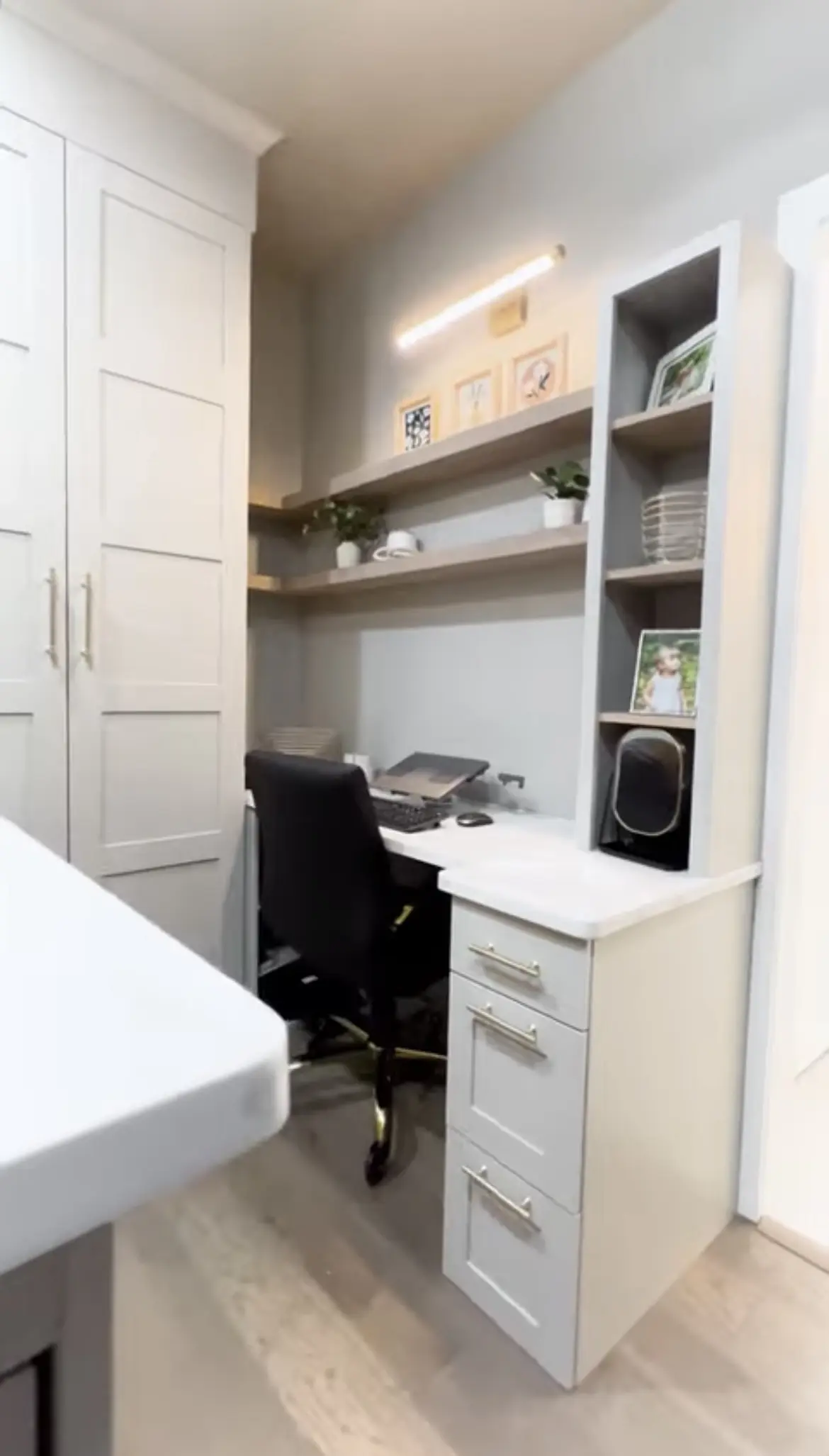 A desk and chair in the corner of a room.