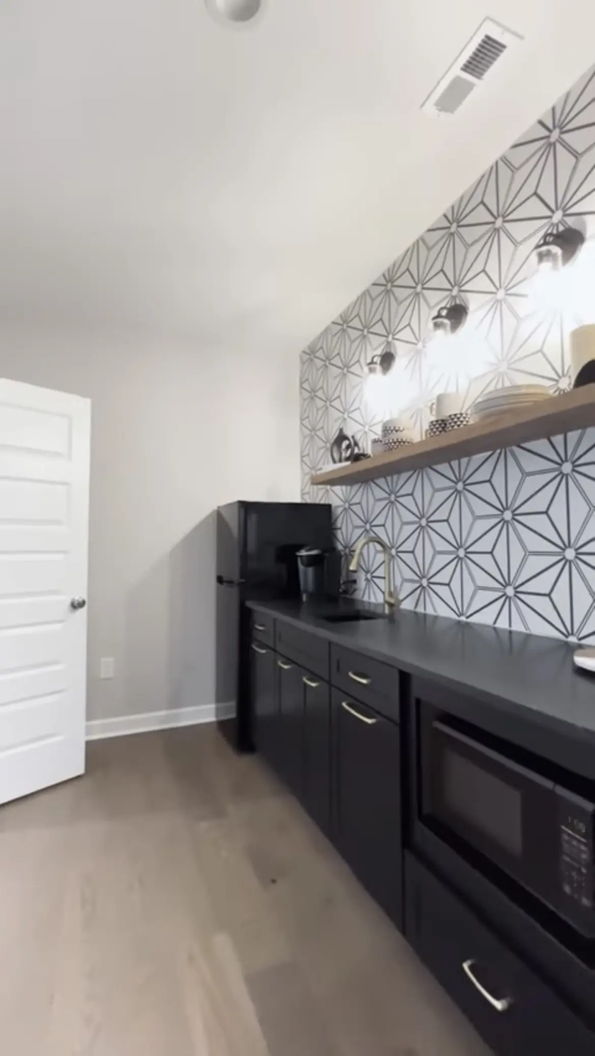 A kitchen with black cabinets and white walls.