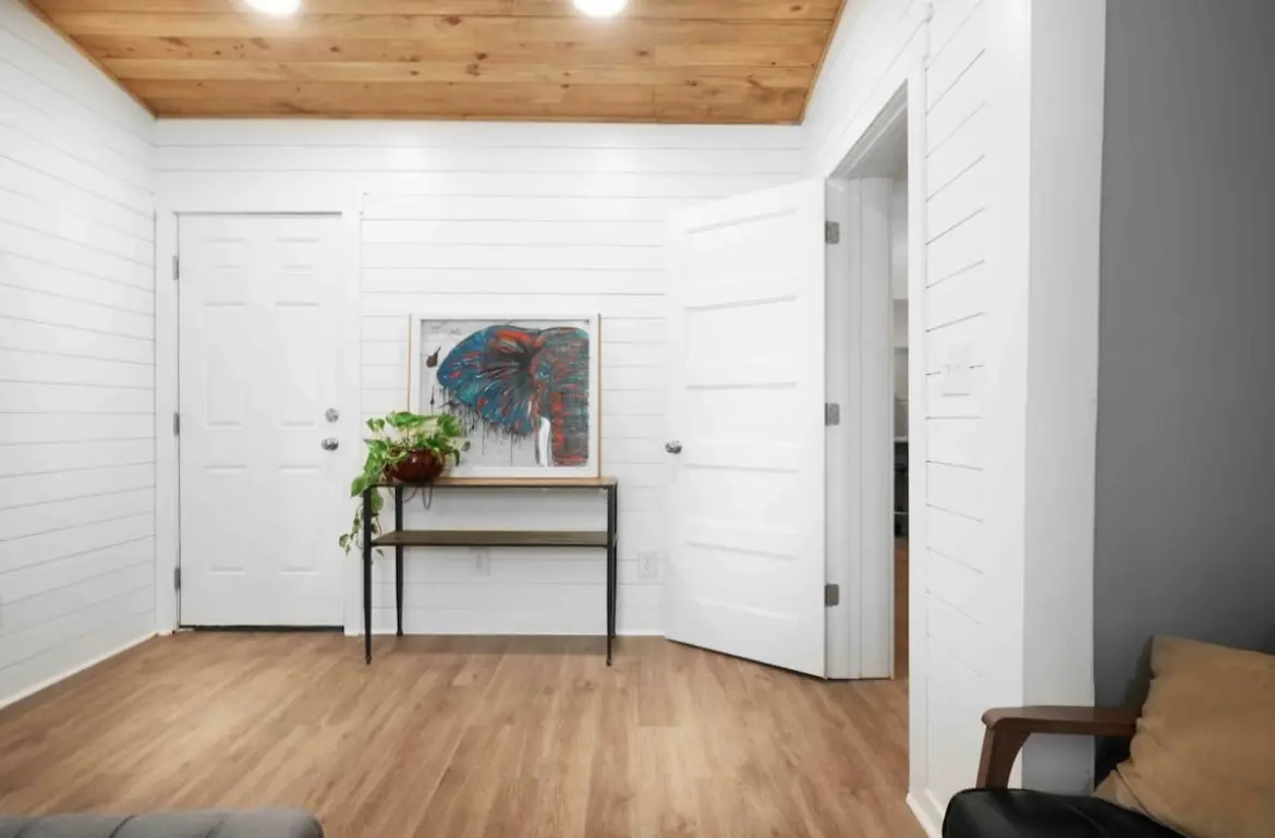 A room with white walls and wooden floors.