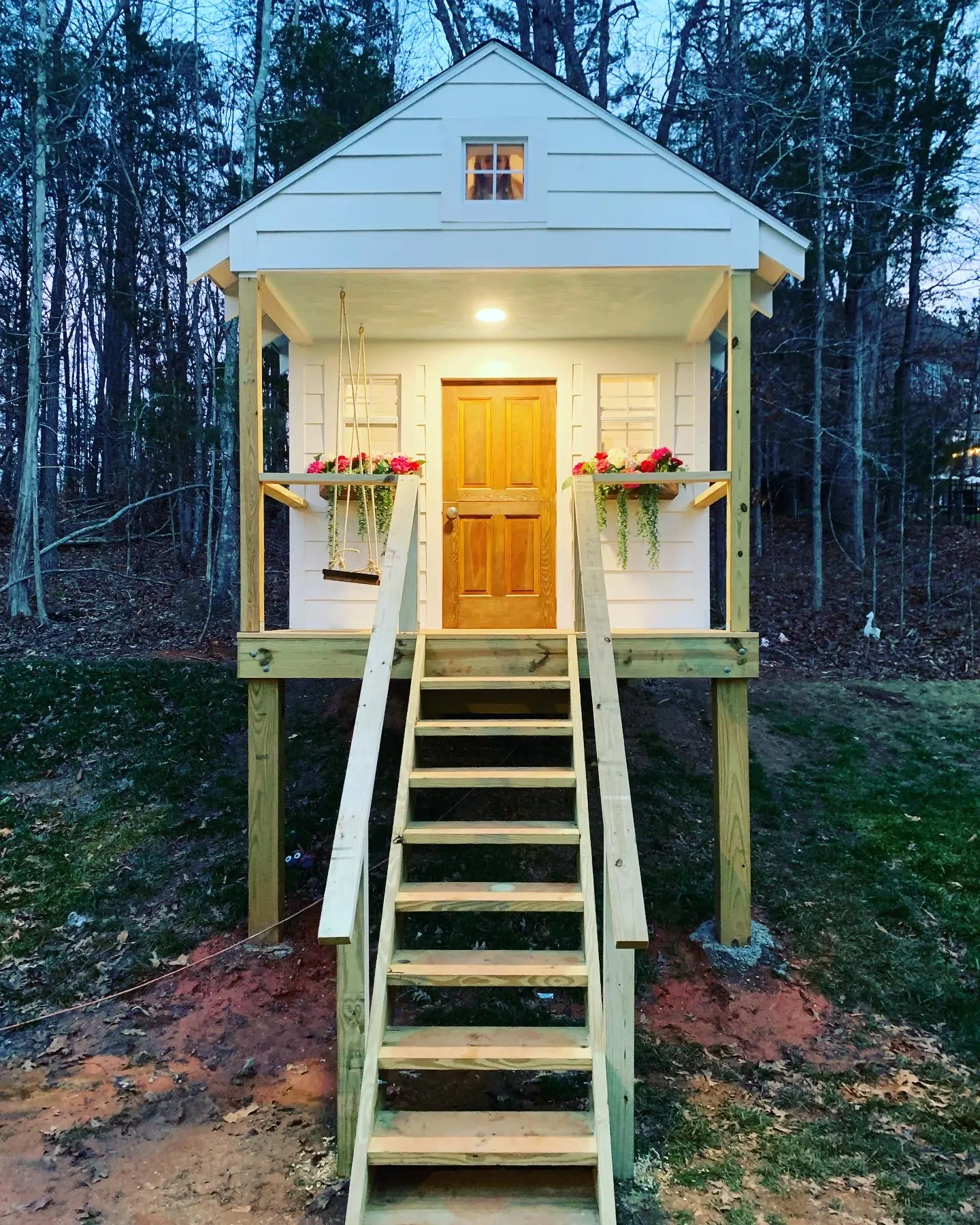 A small house with stairs leading to the front door.