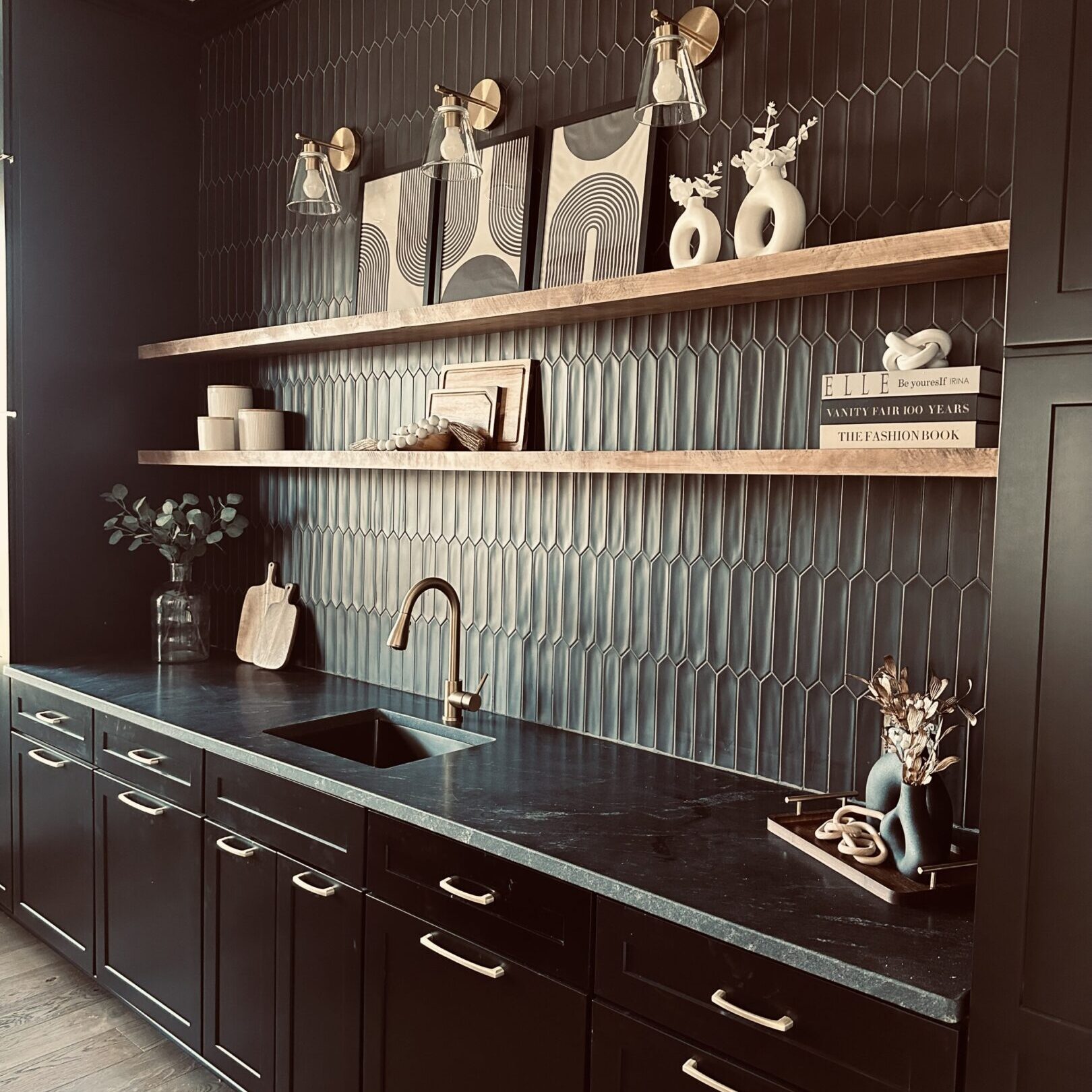 A black kitchen with a sink and shelves